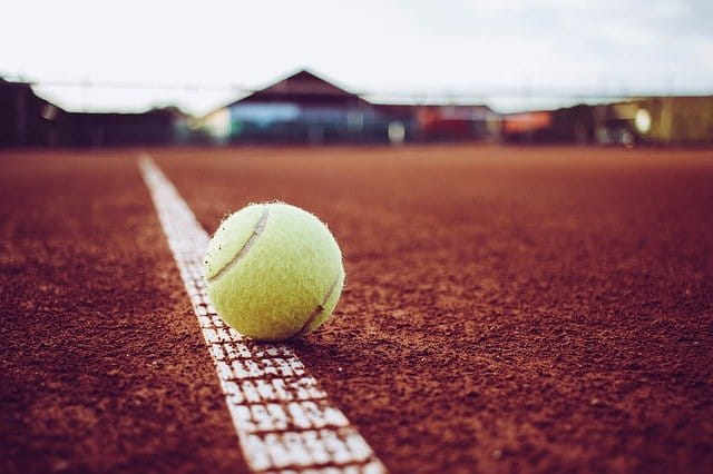 Balle de tennis posée au sol.